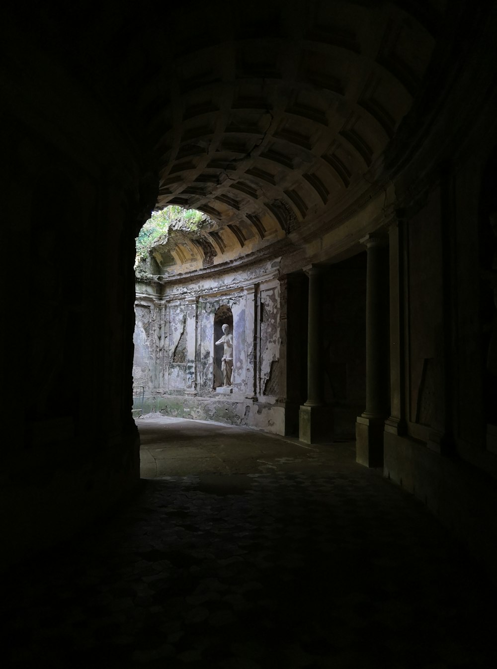 a dark tunnel with a statue in the middle of it