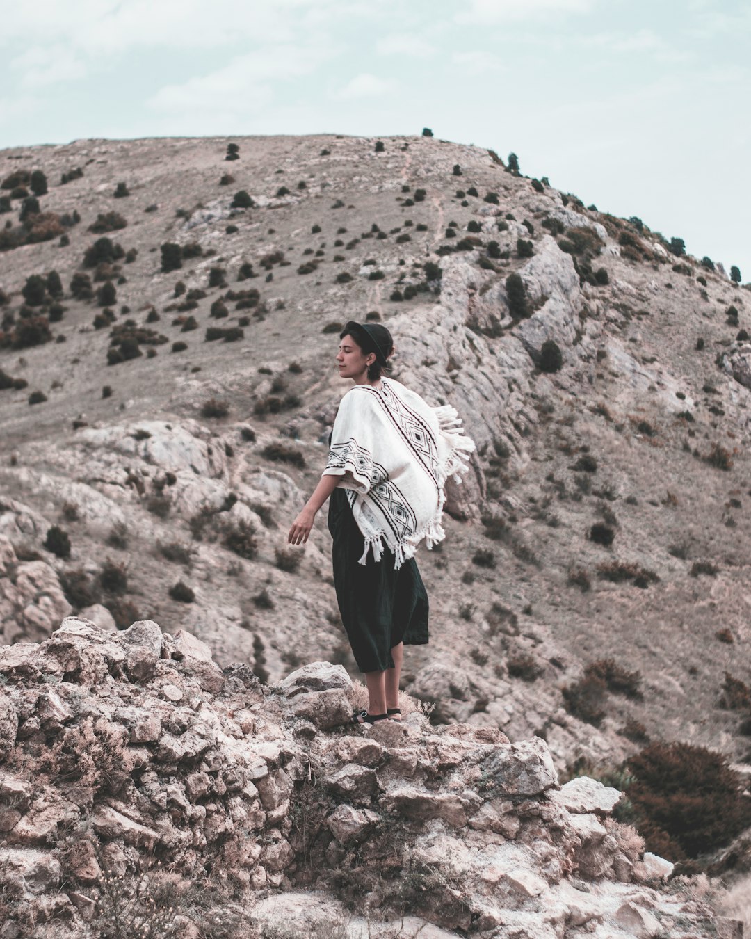 person in white top standing on mountain during daytime