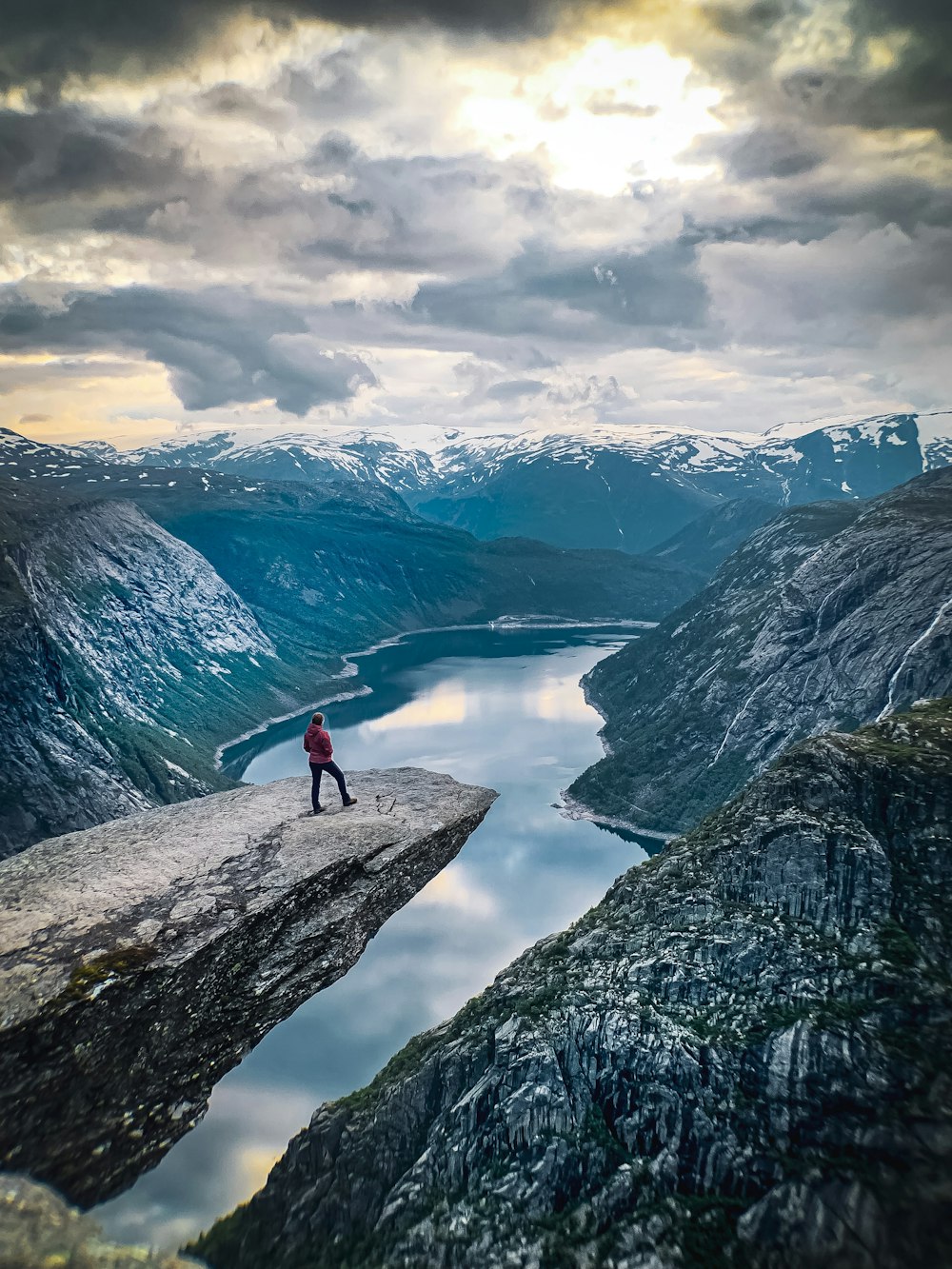 person standing on Trolltunga during daytime