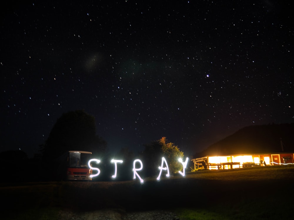the word stray is lit up in the night sky