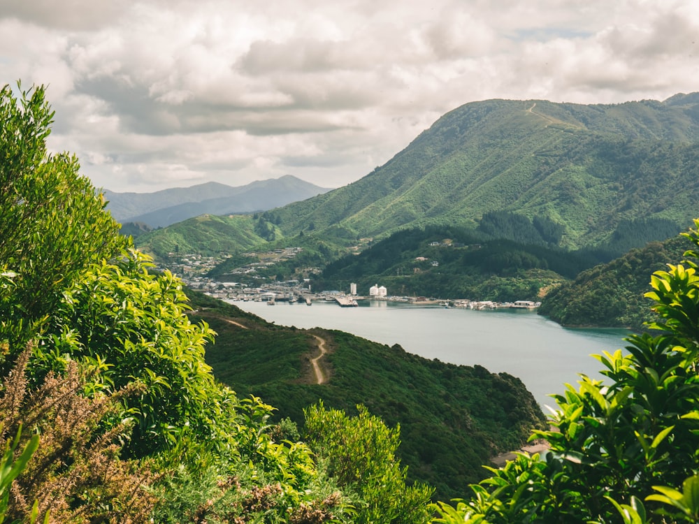 mountain near body of water and buildings during daytime