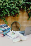 A stack of educational books and study materials on a desk.