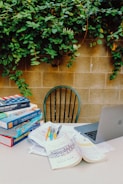 A stack of educational books and study materials on a desk.