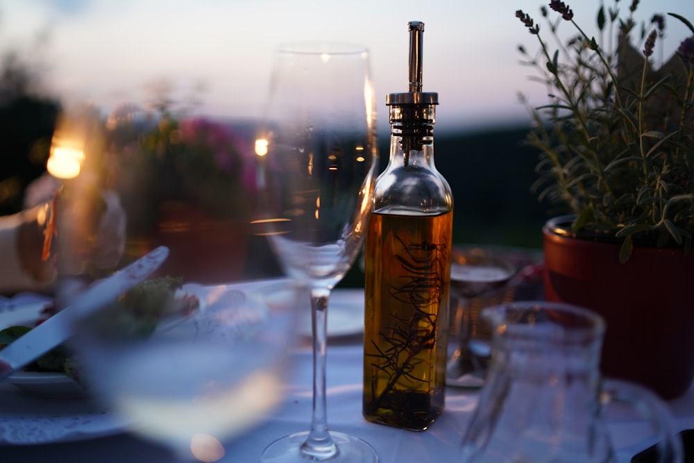bottiglia stampata vicino alla fotografia ravvicinata della tazza di vino in vetro trasparente