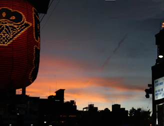 Sunset view over a British city skyline with Moroccan lanterns glowing in the foreground.