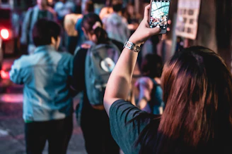 A lively urban night scene in Geneva with people connecting via their smartphones.
