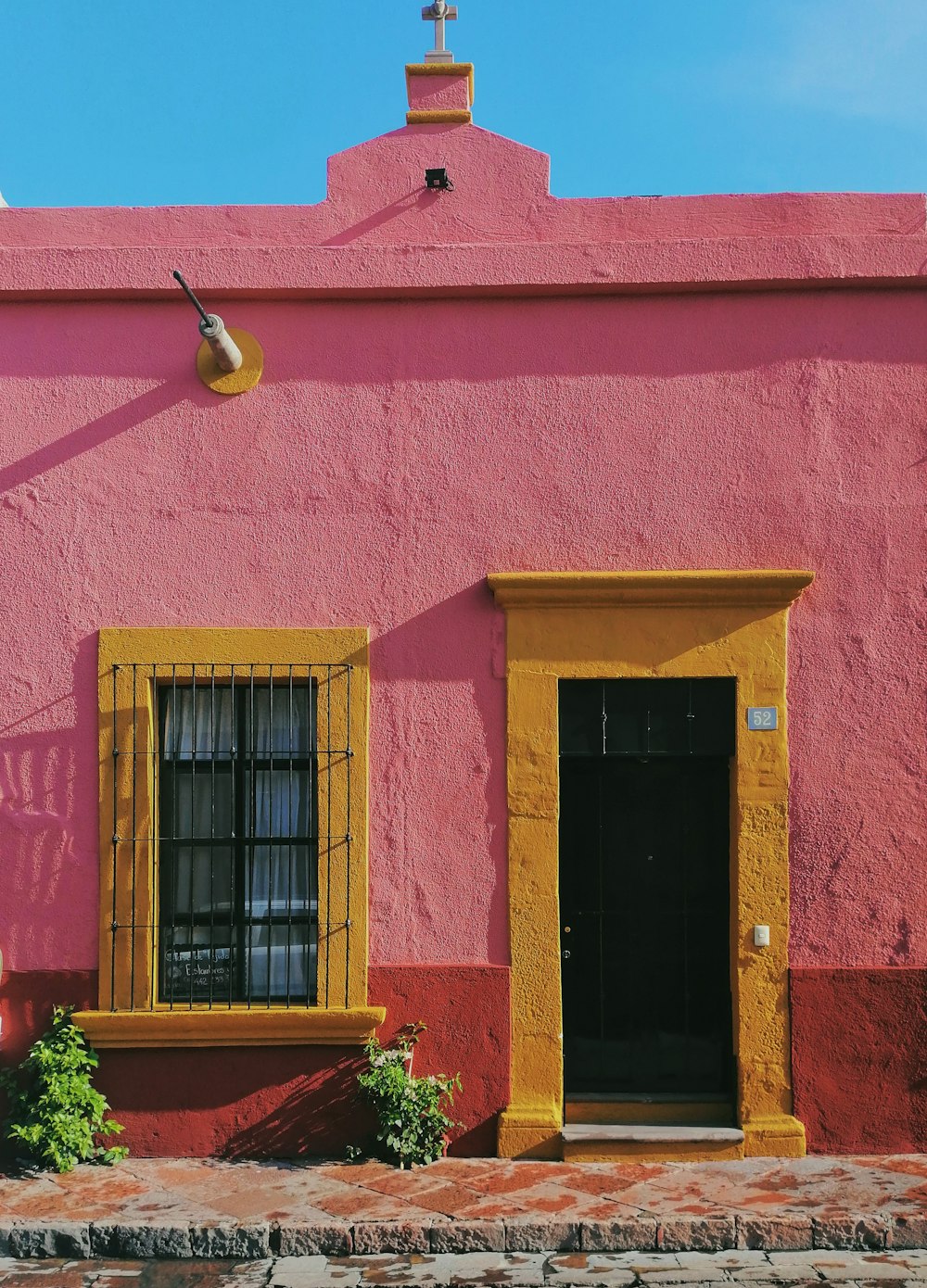 maison en béton rose et jaune pendant la journée
