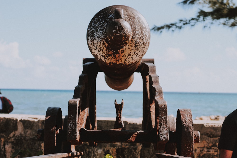 a large metal object sitting on top of a stone wall