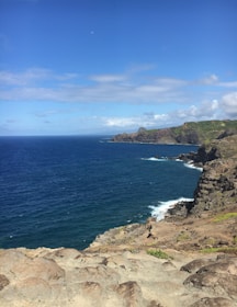 A rugged coastline along South Africa’s Otter Trail, waves crashing against rocky cliffs under a clear blue sky.