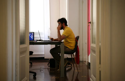 man siting facing laptop computer