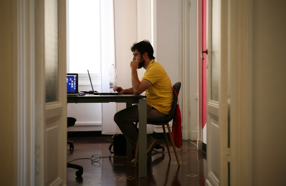 ラップトップコンピュータに面して座っている男性