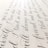 Elegant black cursive handwriting is beautifully arranged on a light-colored paper background, showcasing smooth curves and flowing script.