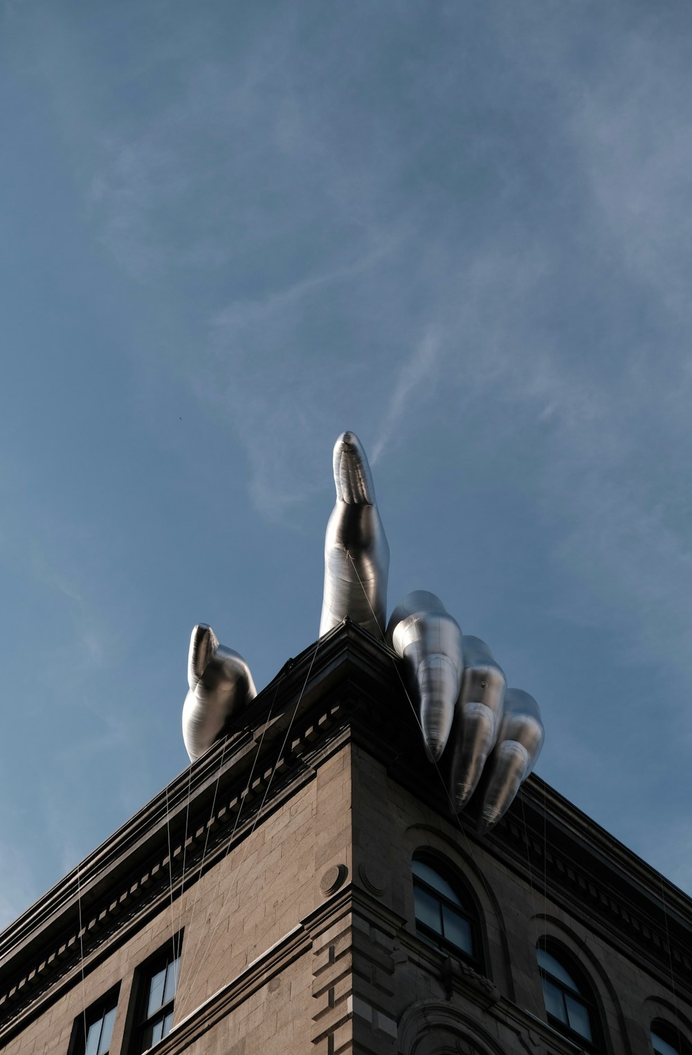 Foto architettonica della mano grigia sull'edificio marrone