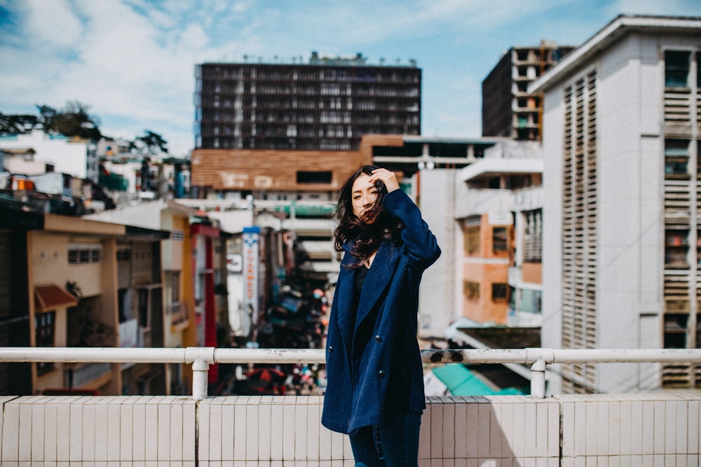 woman standing beside fence near building