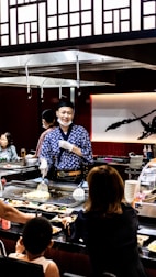Chef Alfonso engaging with guests while preparing food live at an event.