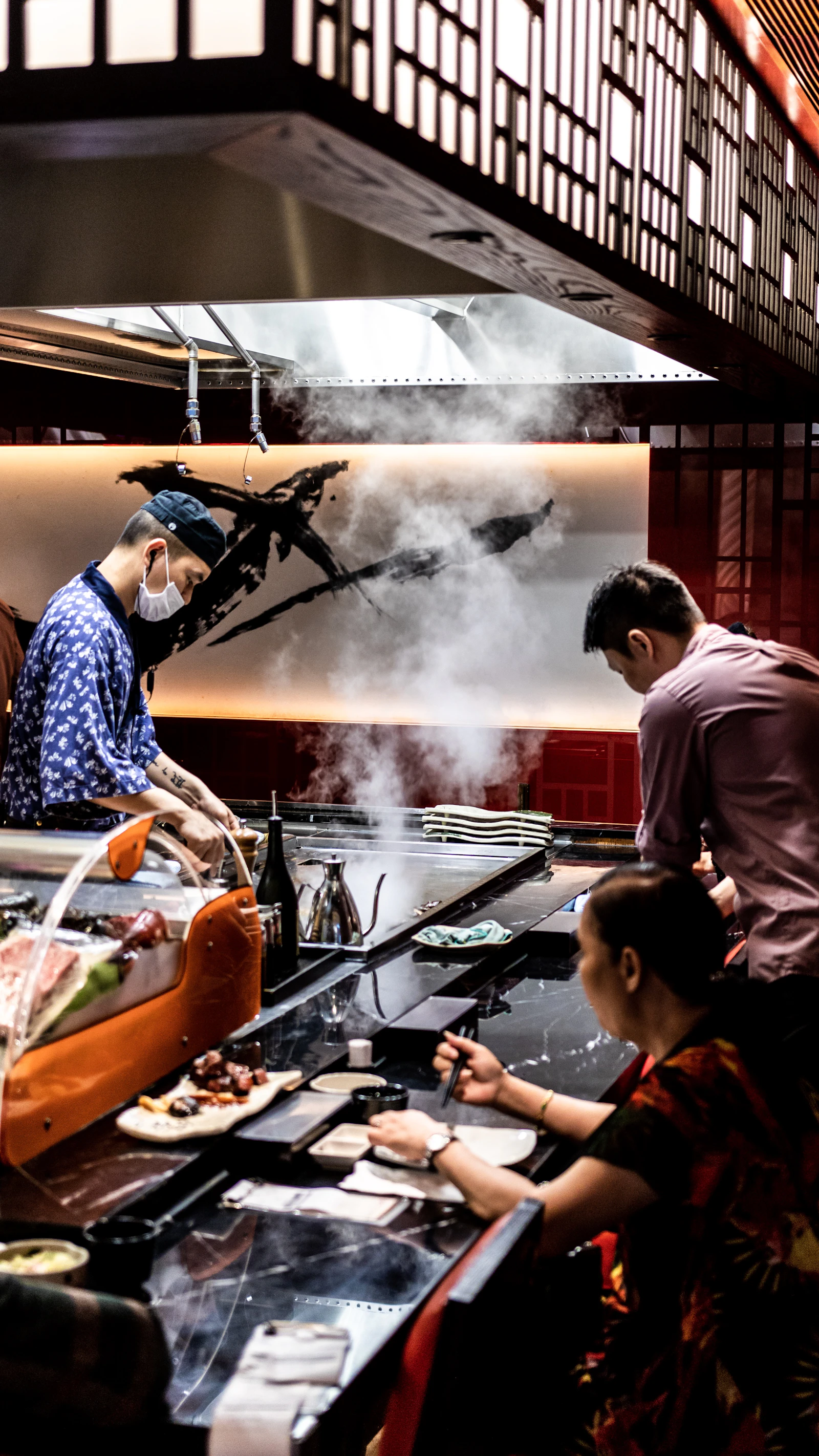 Guests gathered around a teppanyaki grill while a chef cooks