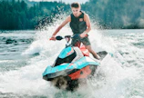 photography of man riding personal watercraft during daytime