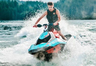 photography of man riding personal watercraft during daytime