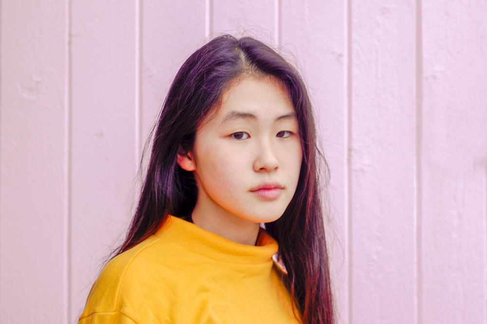 woman standing in front of pink wooden wall