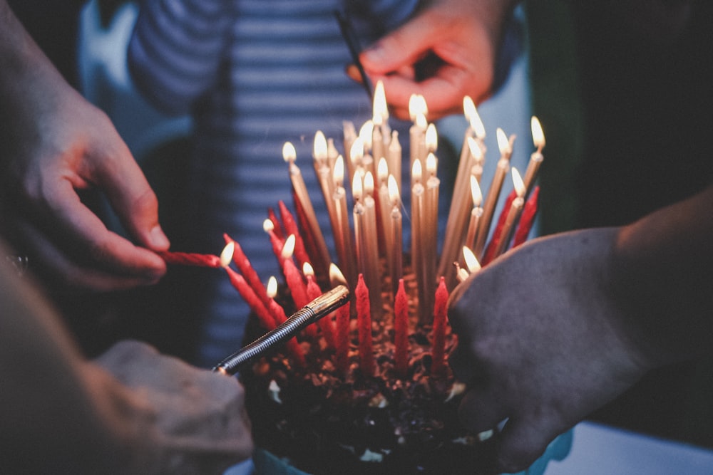 people standing and lighting candles