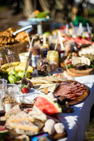 A lively event setup featuring our catering spread with warm breads, savory meals, and local products beautifully arranged.