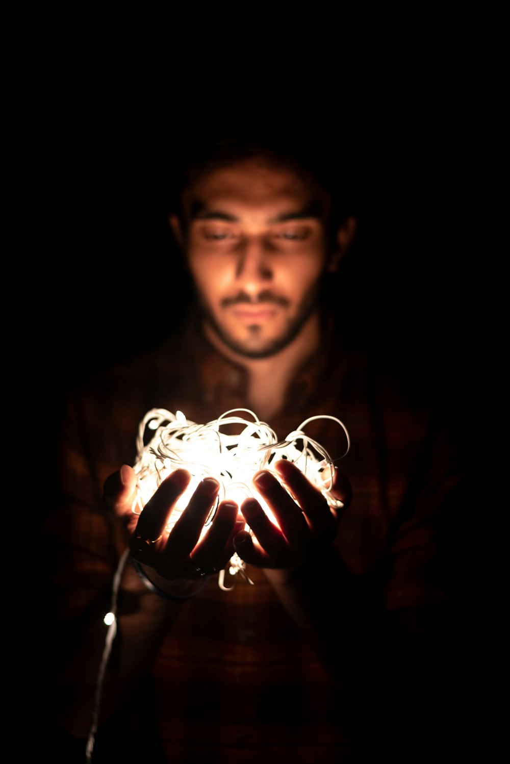 man holding white string lights