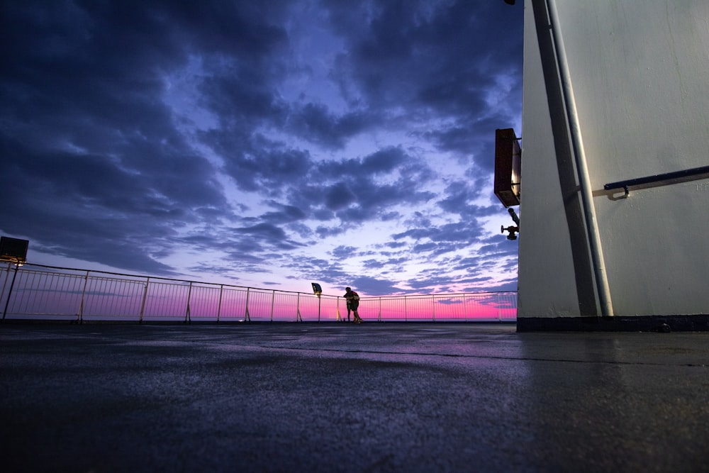 Silhouettenfoto einer Person, die sich auf einen Metallrahmen stützt