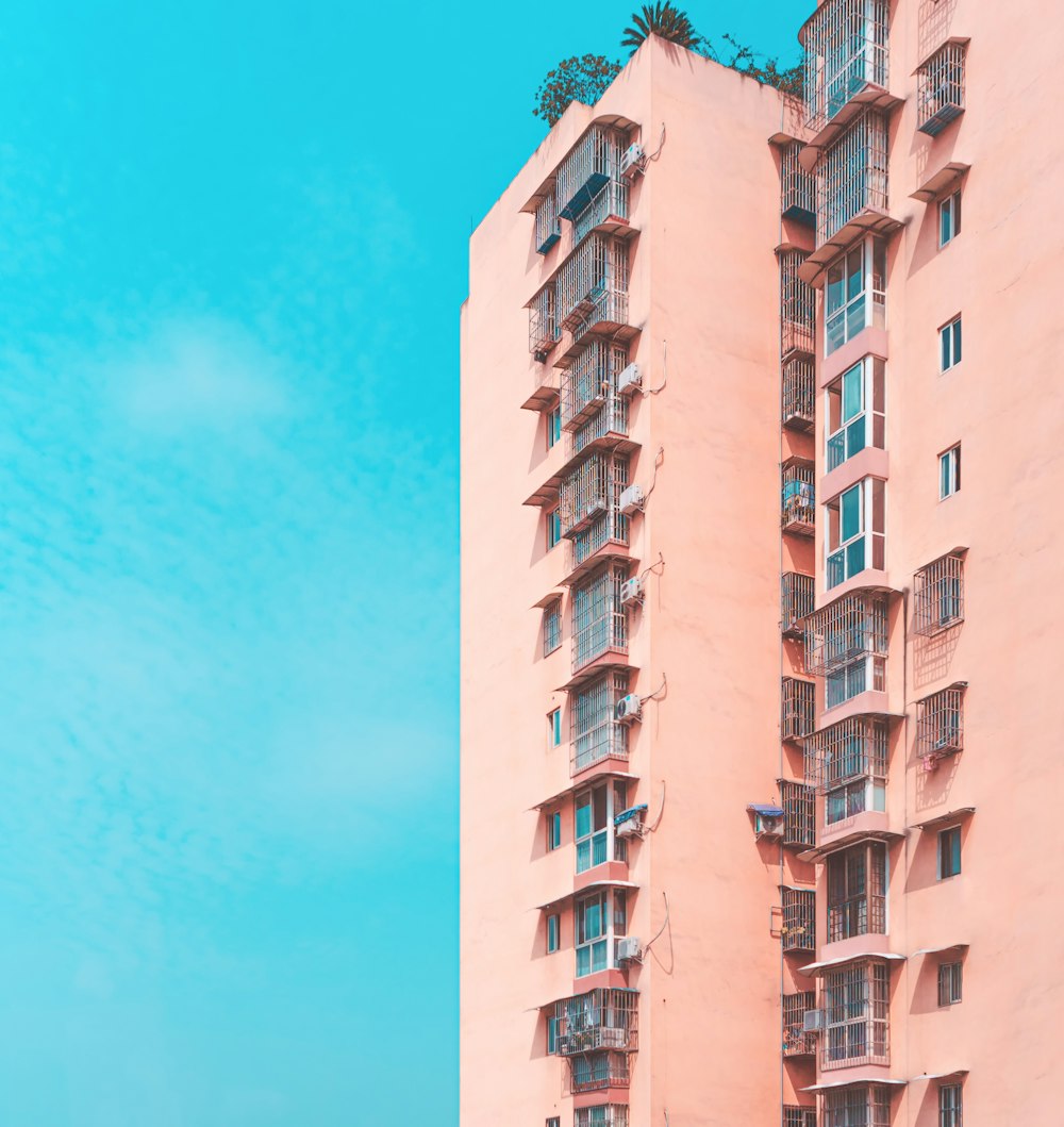 pink condominium building across blue sky