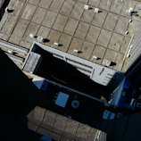 Wide shot of a commercial flat roof with new ventilation and gutter installation in progress.
