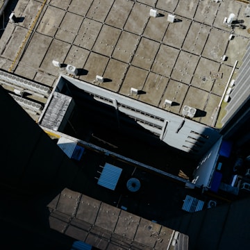 Wide shot of a commercial building where vents are being serviced by technicians.