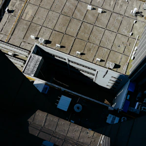 Wide shot of a commercial flat roof with new ventilation and gutter installation in progress.