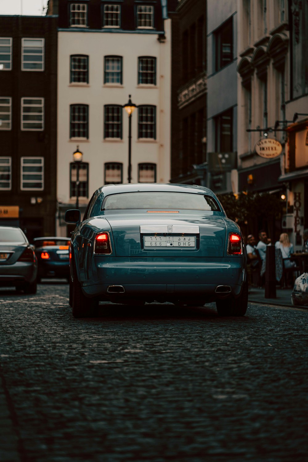 gray car on road between buildings