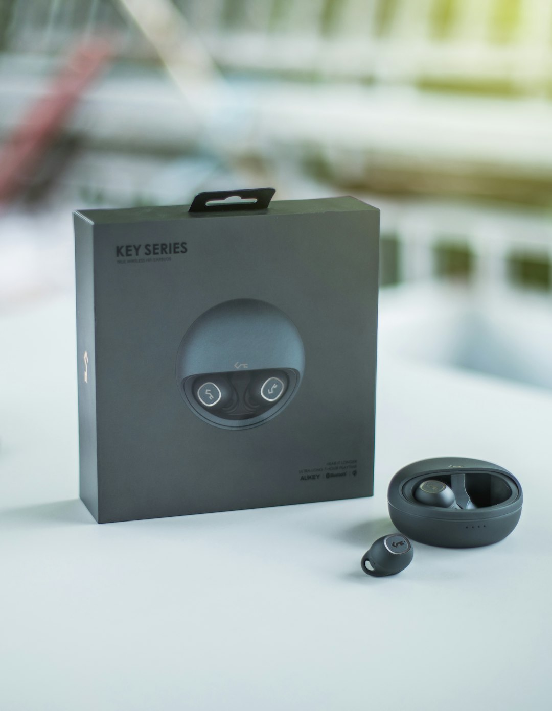 grey Key Series Bluetooth earbuds with case and box