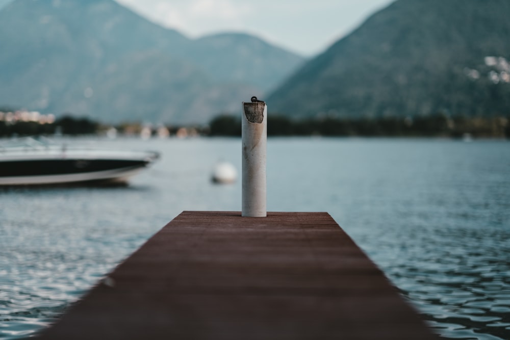 brown wooden dock with white pole across mountain