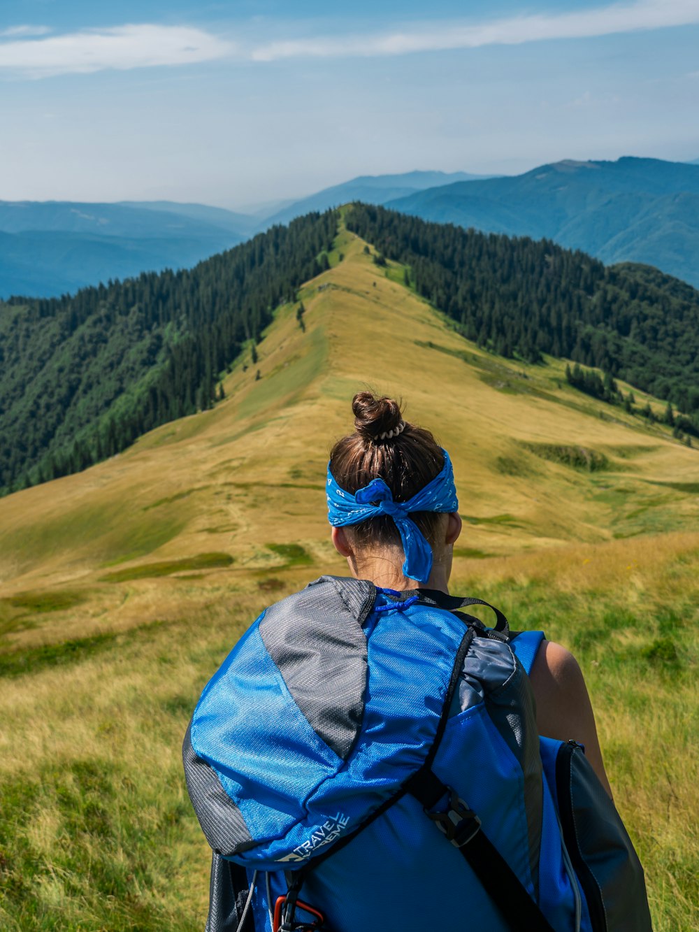 woman carrying a blue and black backpack