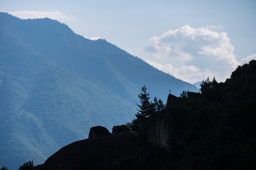 A serene landscape with a cross on a hill at sunset, symbolizing faith and spirituality.