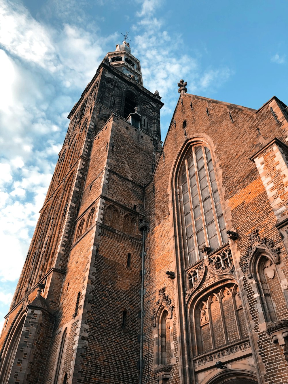 Iglesia de hormigón marrón bajo una nube blanca y un cielo azul durante el día