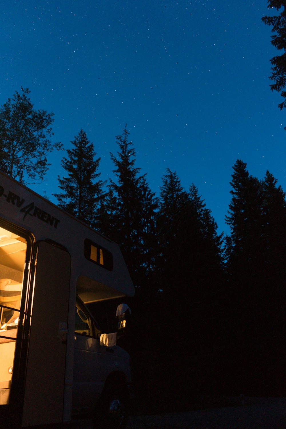 a camper parked in the woods at night