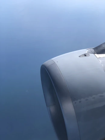 Close-up of a sleek hydrogen engine glowing with blue and white light against a dark aerospace background.