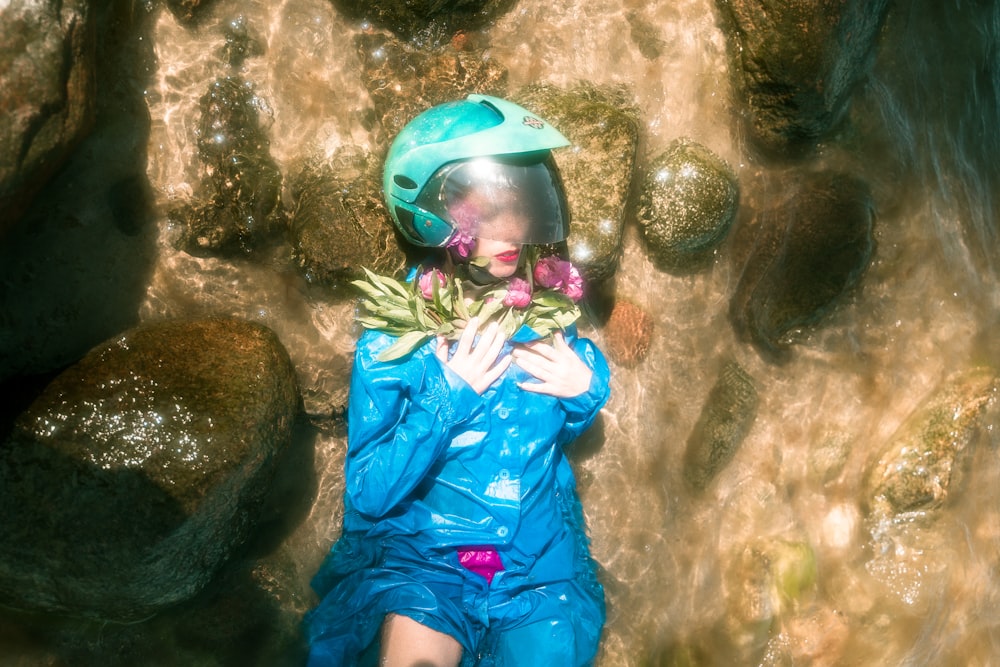 Femme portant un imperméable bleu et un casque intégral noir