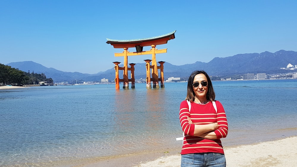 woman standing next to tori gate during daytime