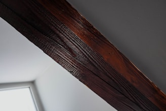 Technician inspecting a wooden beam for termite damage in a Batangas home.