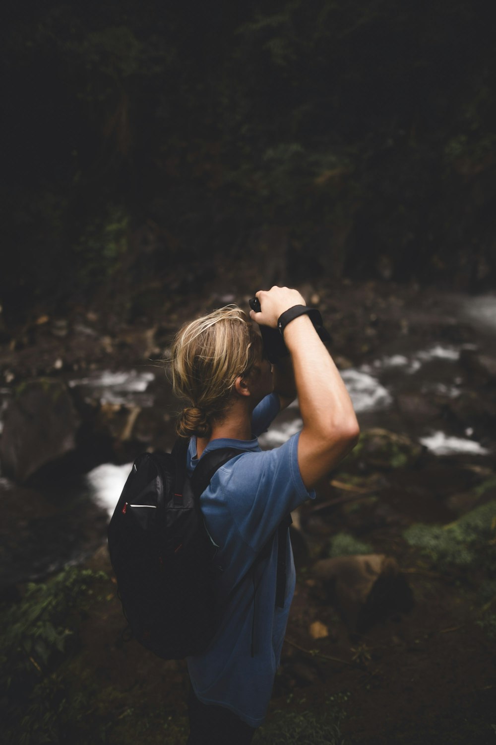 person wearing blue shirt and black backpack