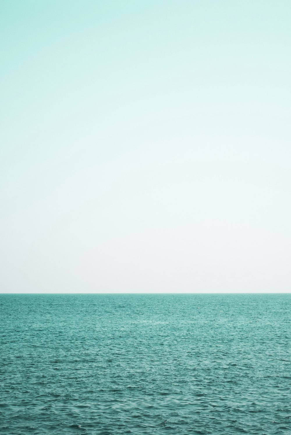 a large body of water sitting under a blue sky