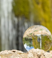 clear glass ball on brown rock