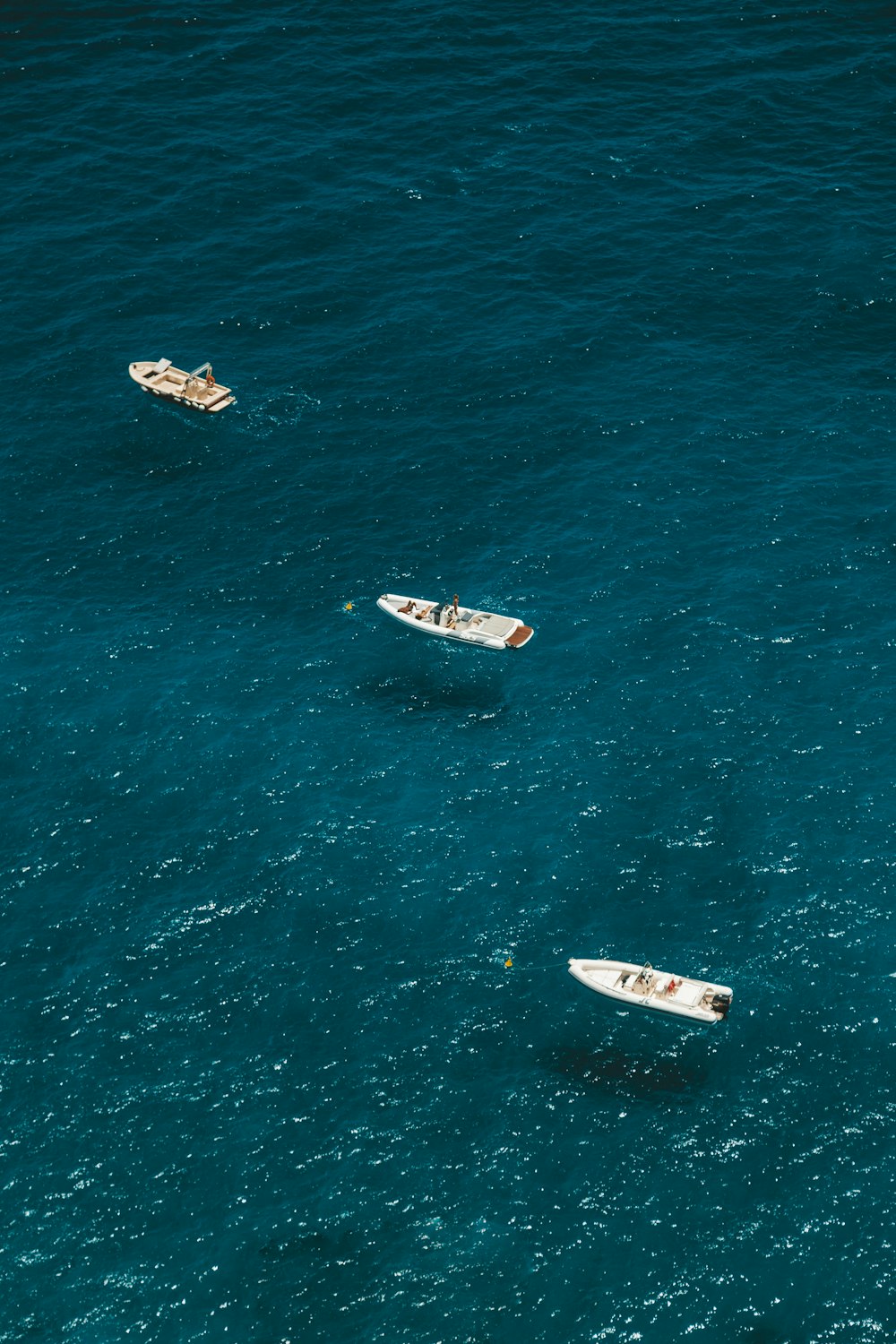 three white boats on body of water at daytime