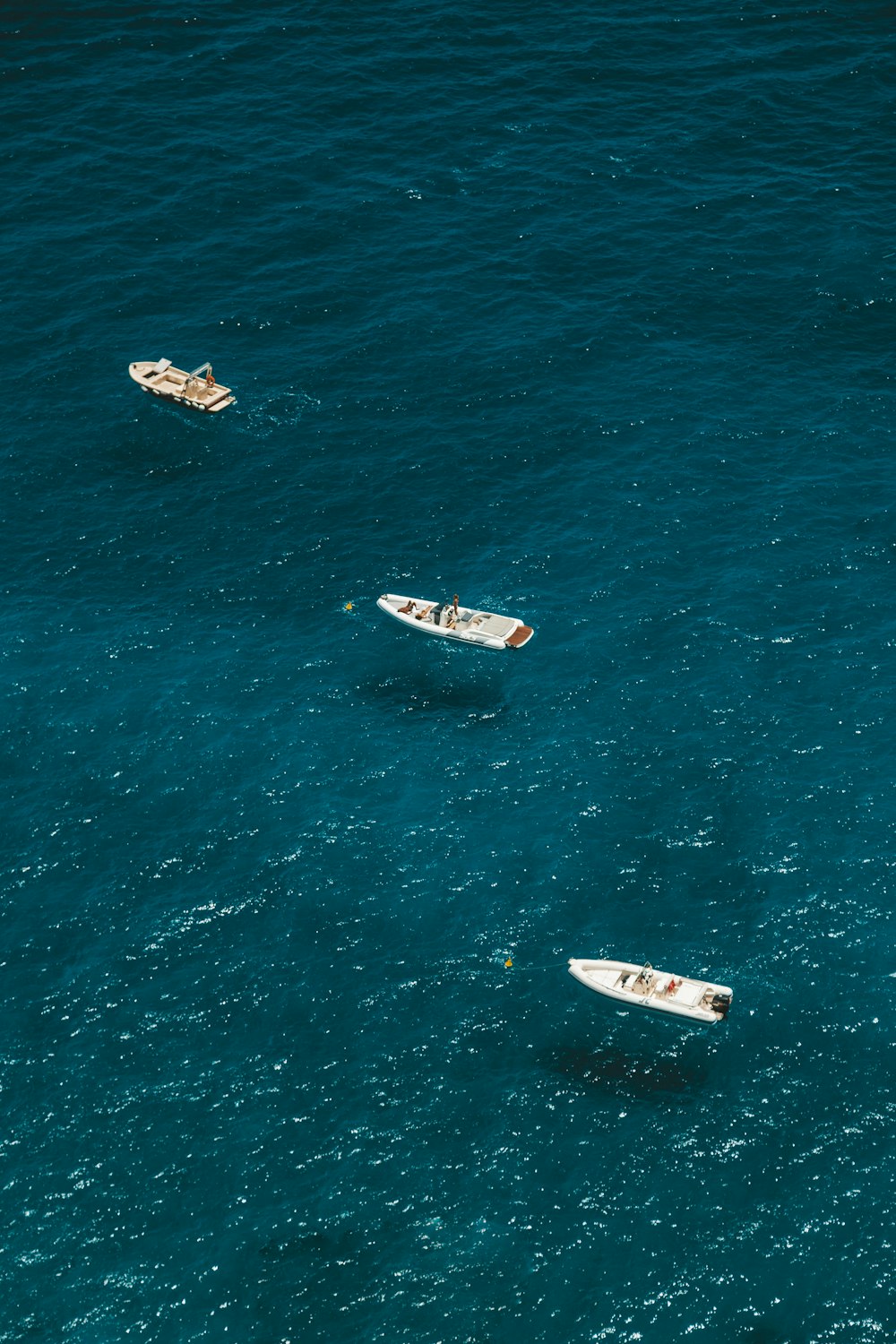 Tres botes blancos en el cuerpo de agua durante el día