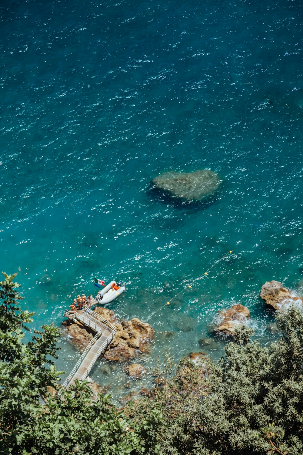 white boat near rock boulder