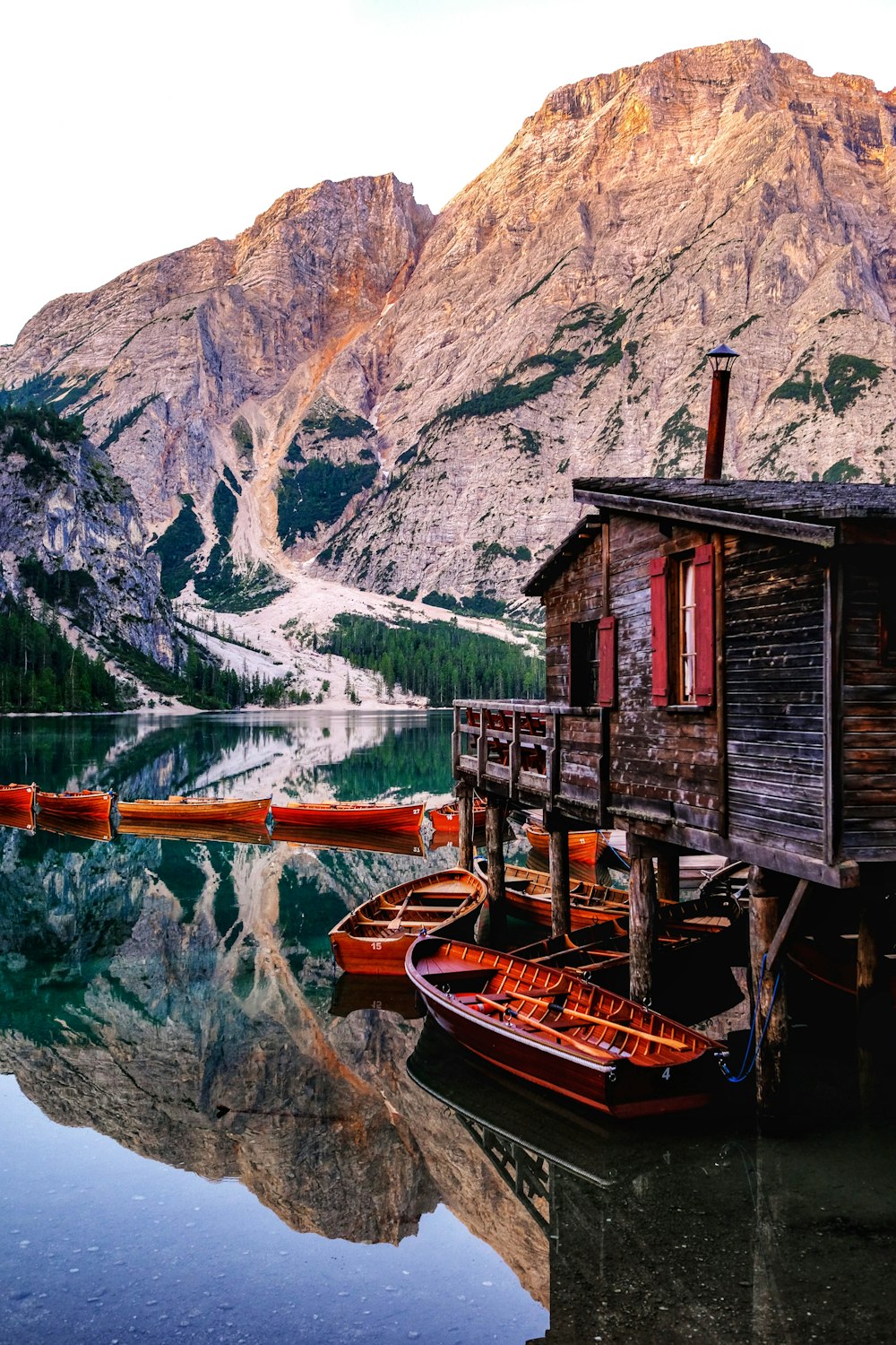 red wooden house beside body of water
