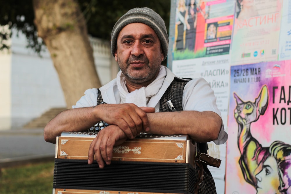 man wearing gray knitted beanie holding accordion